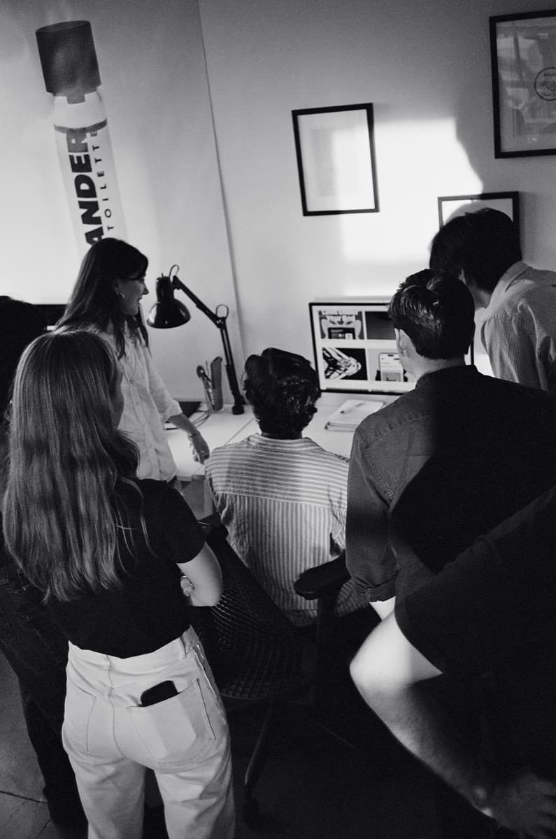 The team gathered around a screen reviewing work